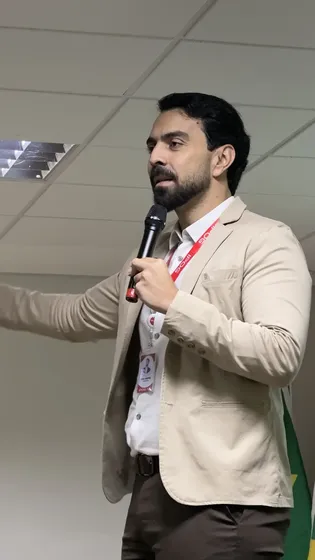 Caio em sala de aula, com microfone